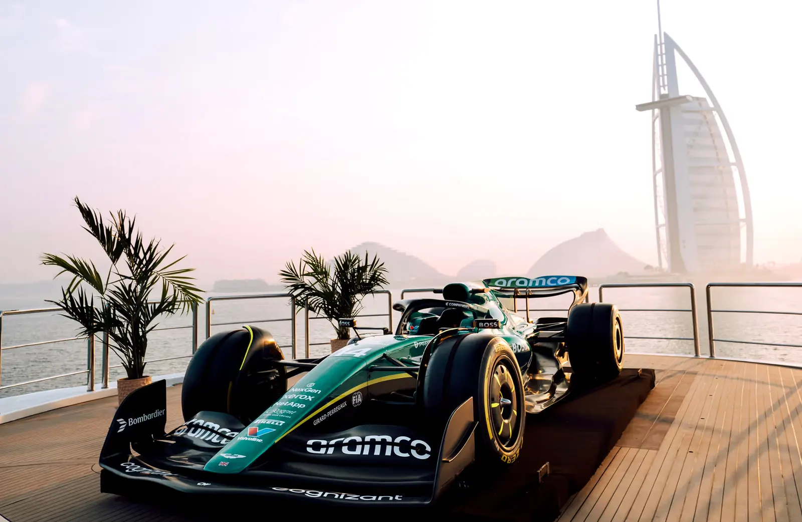 A Formula 1 car displayed on the deck of the Ultimate Superyacht at sunset